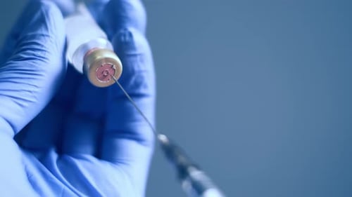 Doctor Hands füllt eine Spritze mit Impfstoff aus einer Flasche