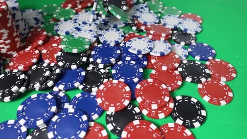 Dropping Poker Chips on a Green Gambling Table in Slowmo