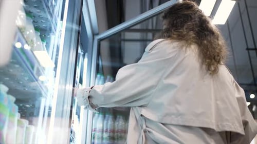 Woman in Trench Coat Buys Dairy Products in Supermarket