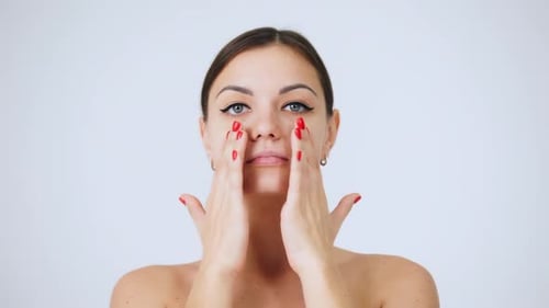 Close-up Portrait of Beautiful Woman Touching Face, Rubbing Cream Into Face Skin