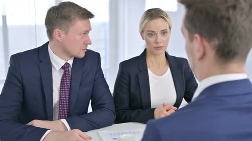 Rear View of Professional Business Team Discussing with Client