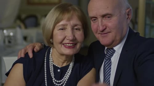 Mature Couple Smiling While Looking at Cellphone Together