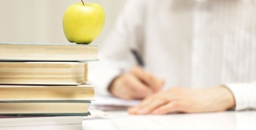 Student Studying with Apple on Books