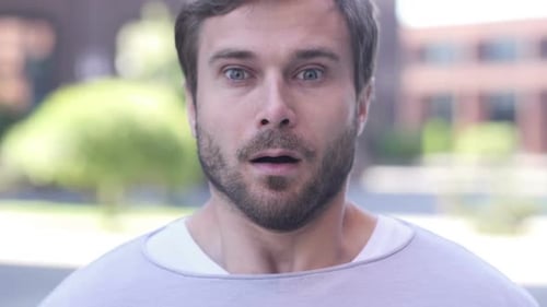 Young Man's Surprised Reaction in Urban Setting