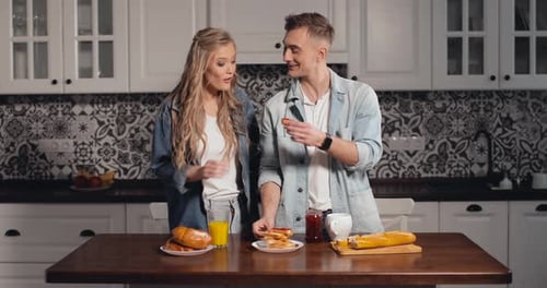 Couple Sharing Bread and Jam in Kitchen
