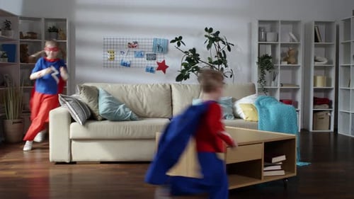 Kids Dressed as Superheroes Playing in the Living Room