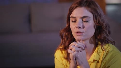 Young Woman Praying with Hopeful Expression