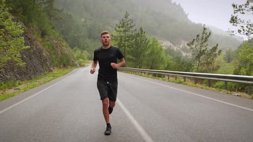 Athletic Man Running on an Empty Road