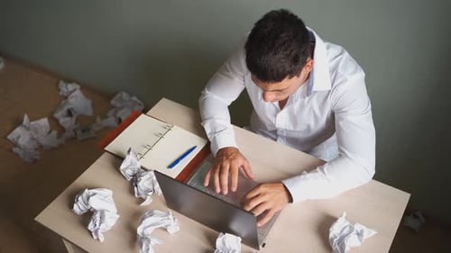 Young Man Working at Desk Feeling Stressed