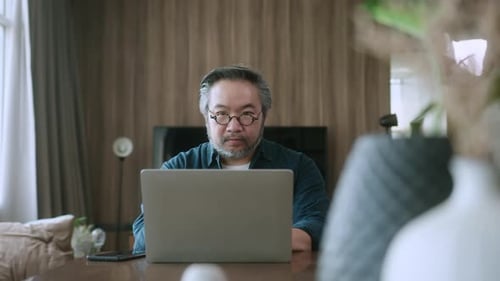 Cheerful Couple Working Together on Laptop Indoors