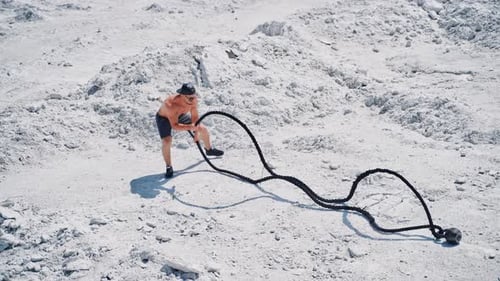Luftaufnahme eines Mannes, der mit Battle Ropes trainiert.