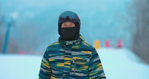 Man is a Snowboarder in Sports Equipment Glasses for Snowboarding are Dressed on His Head