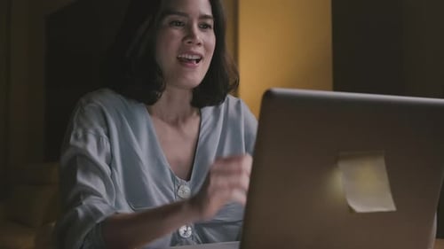 Excited Woman Celebrates Success on Laptop at Home