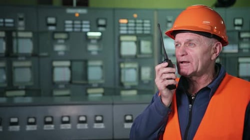 Adult Male Engineer in Protective Helmet Workwear Using Walkie Talkie