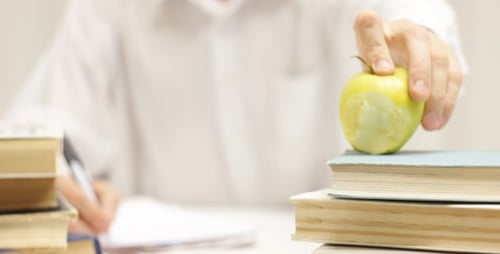 Student Studying with Books and an Apple