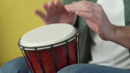 Manos masculinas tocando el djembe bongo en ritmo