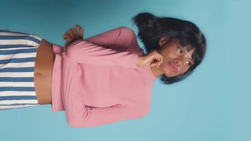 Young Adult Posing in Pink Sweater and Striped Pants