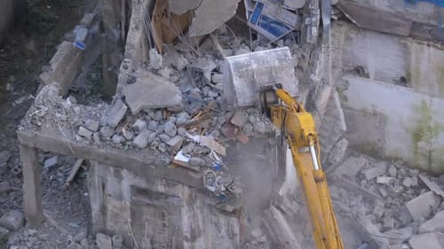 Excavator Demolishing Dilapidated Building in Urban Area