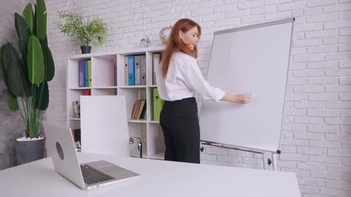 Woman Draws Graph on Whiteboard in Office
