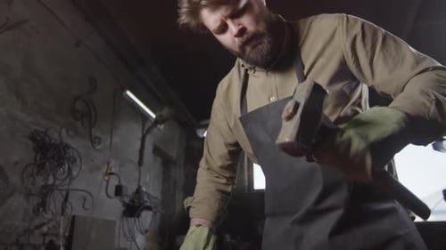 Skilled Blacksmith Shaping Hot Metal in Workshop