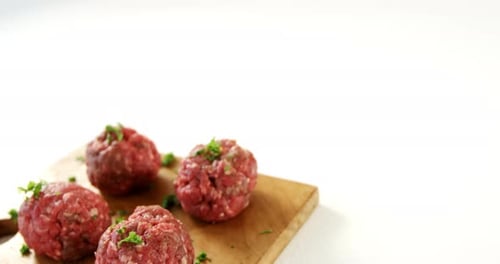Raw Meatballs with Parsley on Cutting Board
