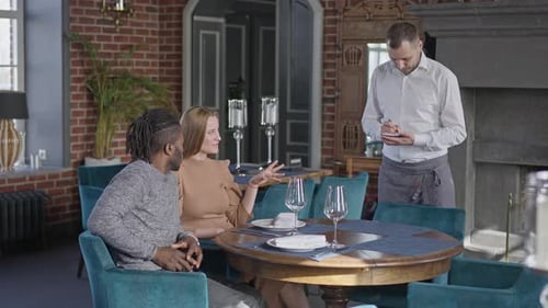 Couple Orders Food From a Waiter in Restaurant