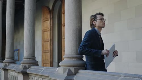 Un étudiant tenant un carnet dans le couloir
