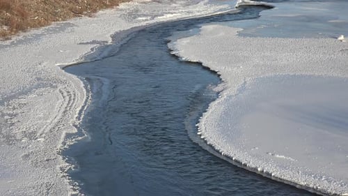 Fluss fließt unter gefrorenen Eisplatten