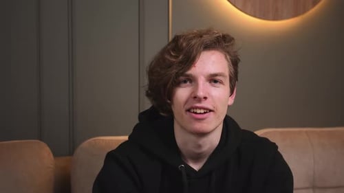 Smiling Young Adult Talks to the Camera Indoors