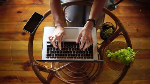 Beautiful girl typing on a laptop top view