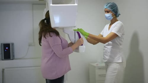 Seitenansicht Professioneller Arzt mit Dental Cone Beam-Scanner untersucht Frauen in Übergröße im Krankenhaus