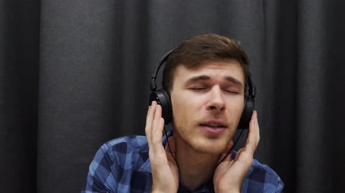 Mann hört Musik über Kopfhörer und singt