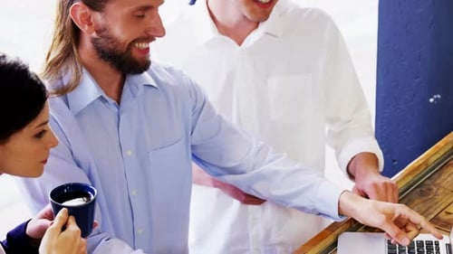 Team Working on Laptop at Cafe