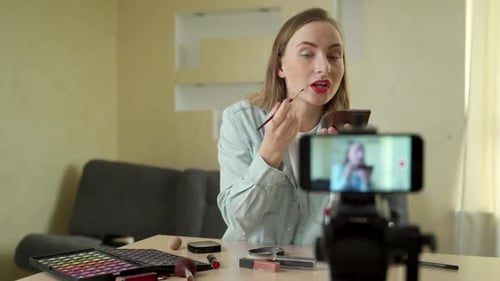 Woman Applies Lipstick, Recording Beauty Tutorial