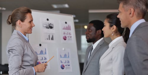 Business Team Discussing Data at Whiteboard