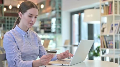 Online Payment on Laptop By Young Businesswoman in Cafe