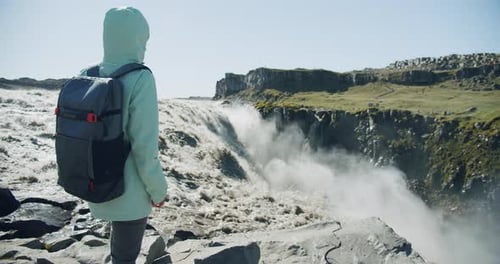 Frau steht vor dem berühmtesten Wasserfall Detifoss in Island