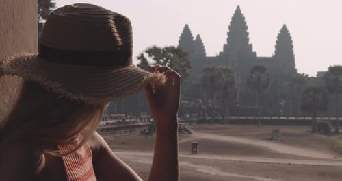 Young Traveler Views an Ancient Structure With the Camera at Her Back