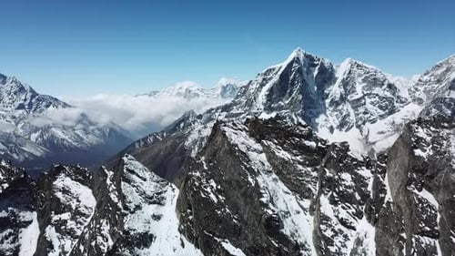 Cinematic drone footage over the snow capped mountain range in Nepal. Clear skies and views over the