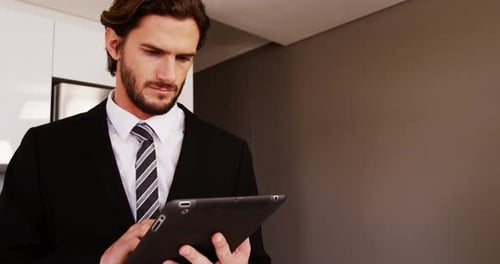 Man in Suit Using Tablet Indoors