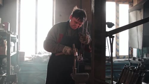 The Blacksmith Forms Petals of Metal By Hitting It with a Hammer