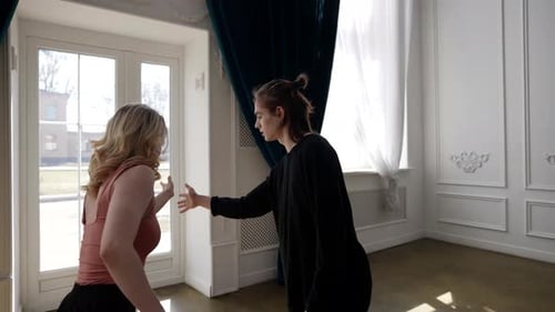 Blonde Woman and Person Dancing Indoors Together