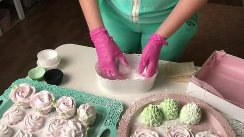 The Woman Sprinkles The Marshmallow With Powdered Sugar.