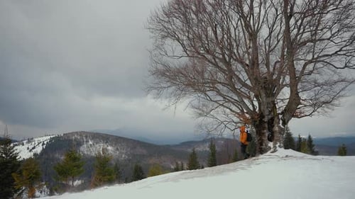 Hiker Walking on Snowy Mountain Ridge in Winter