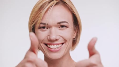 Smiling Woman Gesturing and Winking at Camera