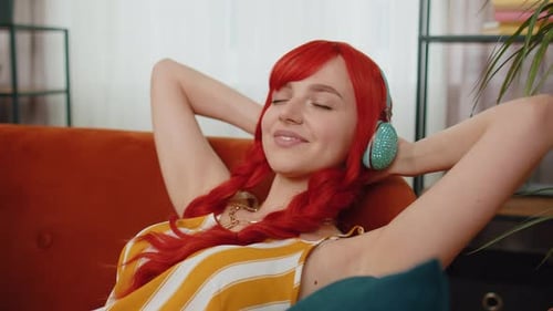 Woman Relaxing on Couch Wearing Headphones