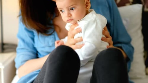 Mother Cradling Adorable Baby at Home