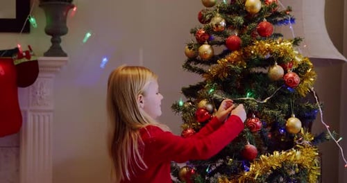 Young Girl Decorating a Christmas Tree at Home
