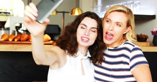 Two Women Laughing While Taking a Selfie