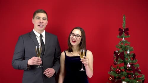 Couple Toasting Champagne Glasses by Christmas Tree